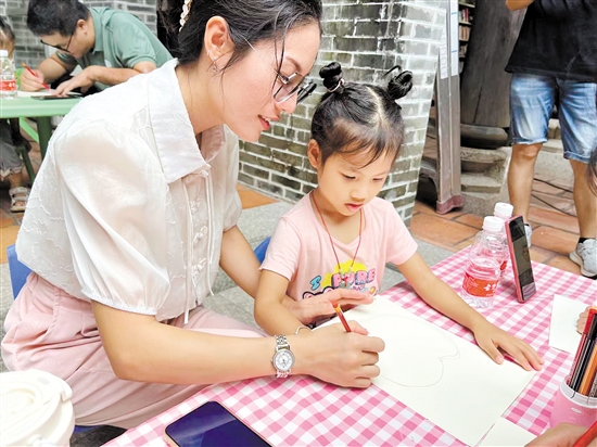 孩子在家長(zhǎng)陪同下創(chuàng)作粘土繪畫作品。