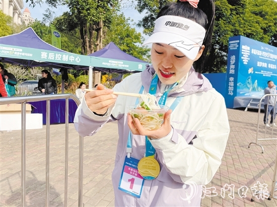 恩平溫泉半程馬拉松女子組冠軍郭利亞品嘗恩平瀨粉并點贊。